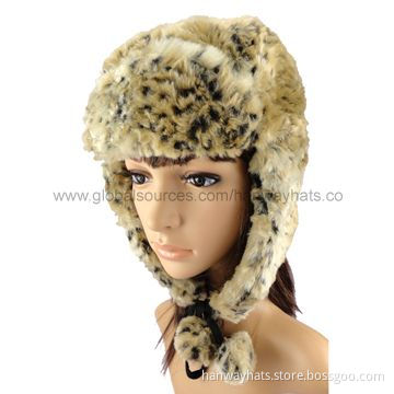 Fashionable winter cap with earflaps with fake fur front, pompoms on the strap